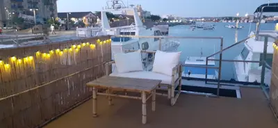 a balcony with a chair and a table and a boat at Casa Flotante El Refugio del Pirata in El Puerto de Santa María