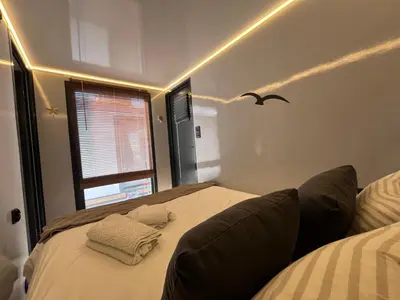 a bedroom with a bed and a bird on the wall at Casa Flotante El Refugio del Pirata in El Puerto de Santa María