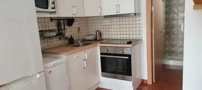 a small kitchen with white cabinets and a sink at Playa Las Redes in El Puerto de Santa María