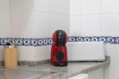 a red appliance sitting on a counter in a kitchen at Apartoyou - Vistahermosa vistas in El Puerto de Santa María
