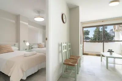 a bedroom with a bed and a table and a window at Apartoyou - Vistahermosa vistas in El Puerto de Santa María