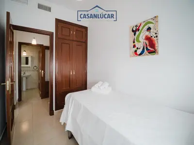 a bedroom with a white bed and a bathroom at Carmen Viejo primero in Sanlúcar de Barrameda