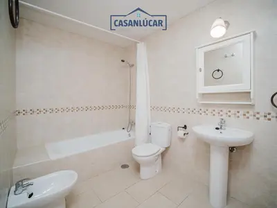 a white bathroom with a toilet and a sink at Carmen Viejo primero in Sanlúcar de Barrameda