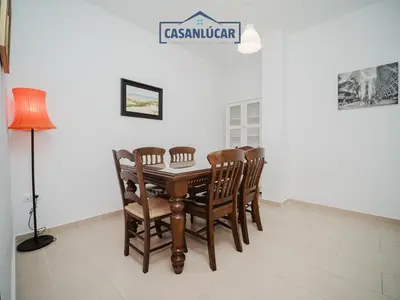 a dining room with a wooden table and chairs at Carmen Viejo primero in Sanlúcar de Barrameda