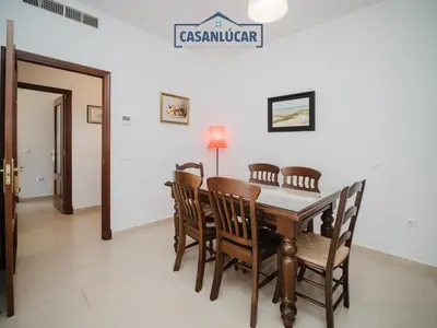a dining room with a wooden table and chairs at Carmen Viejo primero in Sanlúcar de Barrameda