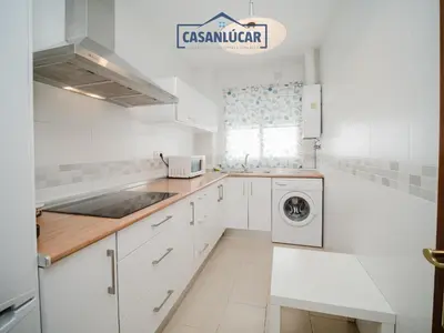 a kitchen with white cabinets and a washer and dryer at Carmen Viejo primero in Sanlúcar de Barrameda