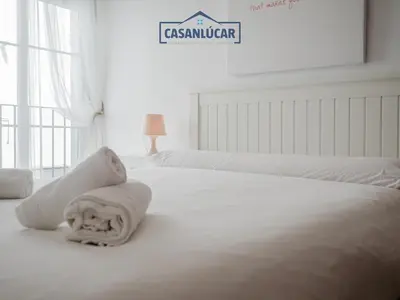 a white bedroom with two beds and a sign that reads casserole at Carmen Viejo primero in Sanlúcar de Barrameda