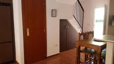 a dining room with a table and a stairway at Al- Andalus in Novo Sancti Petri
