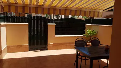 a patio with a table and chairs and a black fence at Al- Andalus in Novo Sancti Petri