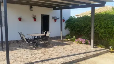 a patio with a table and chairs in a house at LOFT Ajardinado en Roche CONIL in Conil de la Frontera