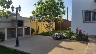 a street light next to a house with a garden at LOFT Ajardinado en Roche CONIL in Conil de la Frontera