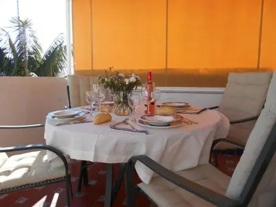 a table with a white table cloth and plates and glasses at Apartamento Caracola Comfortable holiday residence in Chipiona