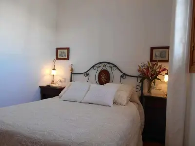 a bedroom with a white bed with two pillows at Apartamento Caracola Comfortable holiday residence in Chipiona