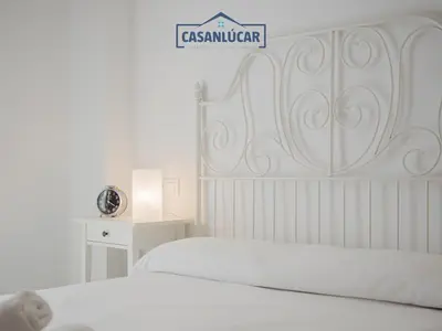 a bedroom with two beds and a sign on the wall at Carmen Viejo bajo in Sanlúcar de Barrameda