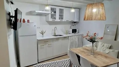 a kitchen with a table and a white refrigerator at GuestReady - La Merced Cadiz in Cádiz