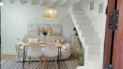 a dining room with a table and white chairs at GuestReady - La Merced Cadiz in Cádiz
