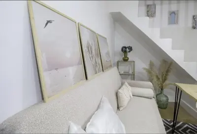 a living room with a white couch with three pictures on the wall at GuestReady - La Merced Cadiz in Cádiz
