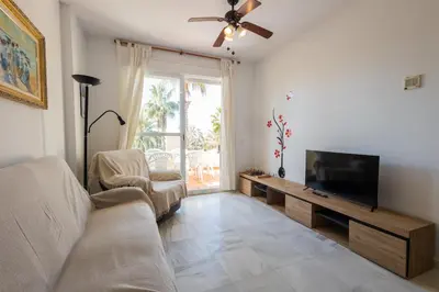 a living room with a couch and a flat screen tv at Costa Ballena - Apt para 6 con piscina, terraza, WiFi y parking gratis in Rota