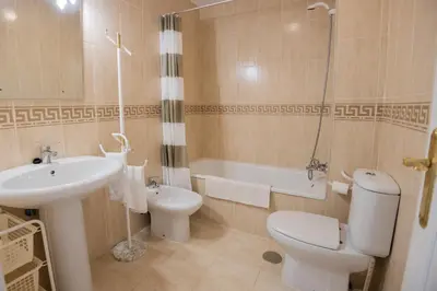 a bathroom with a sink and a toilet and a shower at Costa Ballena - Apt para 6 con piscina, terraza, WiFi y parking gratis in Rota