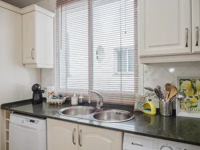a kitchen counter with a sink and a window at La casa del Ceramista in Sanlúcar de Barrameda