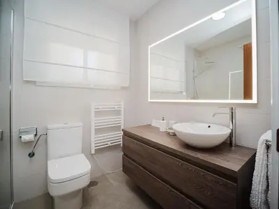 a bathroom with a sink and a toilet and a mirror at La casa del Ceramista in Sanlúcar de Barrameda