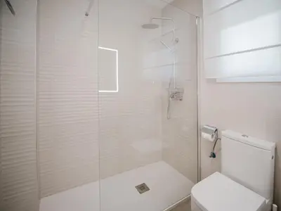 a bathroom with a glass shower with a toilet at La casa del Ceramista in Sanlúcar de Barrameda