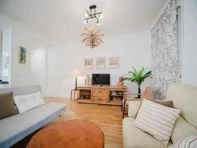 a living room with a couch and a tv at La casa del Ceramista in Sanlúcar de Barrameda