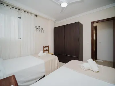 a bedroom with two beds and a cabinet at La casa del Ceramista in Sanlúcar de Barrameda