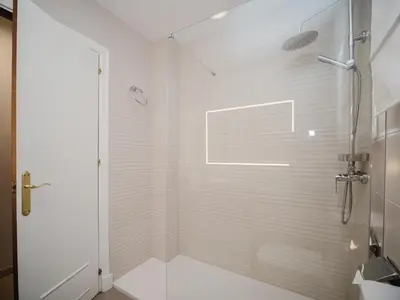 a white shower with a glass door in a bathroom at La casa del Ceramista in Sanlúcar de Barrameda