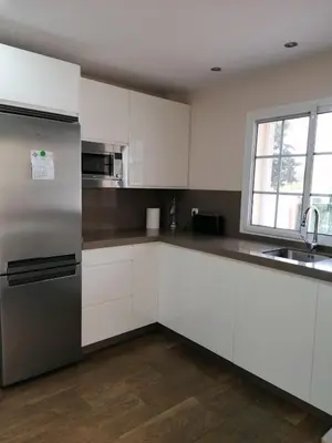 a kitchen with white cabinets and a stainless steel refrigerator at Vivienda en Jerez de la Frontera in Jerez de la Frontera