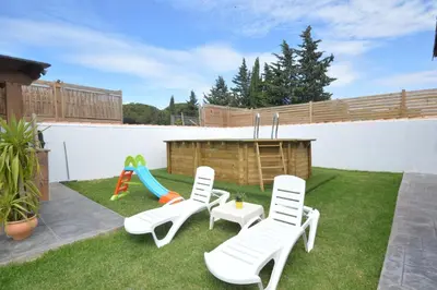 a backyard with a playground with chairs and a slide at Villa Farom in Cádiz