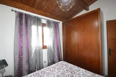 a bedroom with a bed and a wooden cabinet and a window at Villa Farom in Cádiz