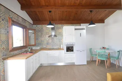 a kitchen with a white refrigerator and a table at Villa Farom in Cádiz