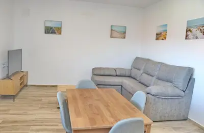 a living room with a table and a couch at Casa Nispero in Conil de la Frontera