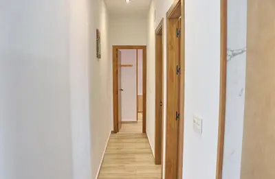 a hallway of a house with white walls and wooden floors at Casa Nispero in Conil de la Frontera