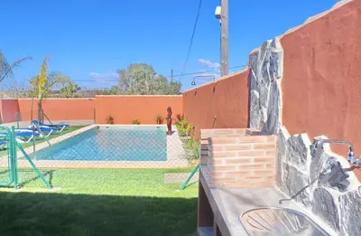 a backyard with a swimming pool and a playground at Casa Nispero in Conil de la Frontera