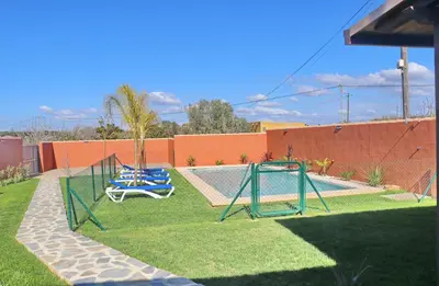 a yard with two swings and a swimming pool at Casa Nispero in Conil de la Frontera