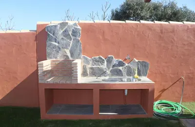 a stone retaining wall with a sink in a yard at Casa Nispero in Conil de la Frontera
