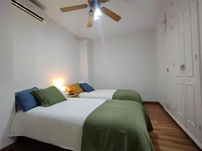 a bedroom with two beds and a ceiling fan at Virgen de los Milagros in El Puerto de Santa María