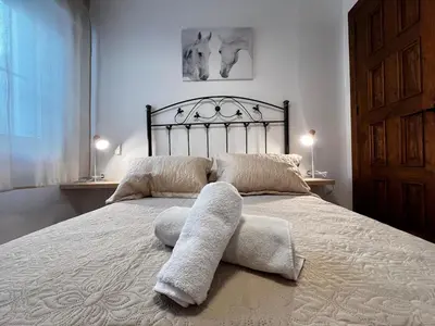 a bedroom with a large bed with towels on it at CasaLola in Sanlúcar de Barrameda