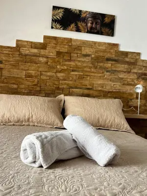 a bed with two pillows and a brick wall at CasaLola in Sanlúcar de Barrameda