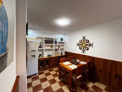 a kitchen with a table and a white refrigerator at CasaLola in Sanlúcar de Barrameda