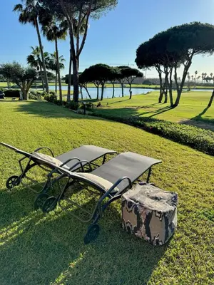 a bench sitting in the grass with a box at Apto Lujo Exclusivo vistas Golf y Mar in Novo Sancti Petri