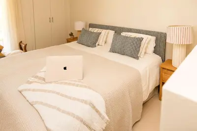 a bedroom with a bed with a laptop on it at Apto Lujo Exclusivo vistas Golf y Mar in Novo Sancti Petri