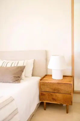 a bed with a table with a lamp on it at Apto Lujo Exclusivo vistas Golf y Mar in Novo Sancti Petri