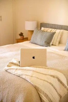 a laptop computer sitting on top of a bed at Apto Lujo Exclusivo vistas Golf y Mar in Novo Sancti Petri