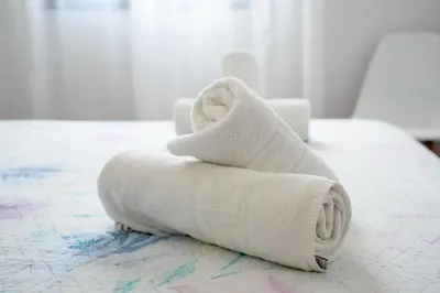 a pile of towels sitting on top of a bed at Casas Rurales Pericón in Conil de la Frontera