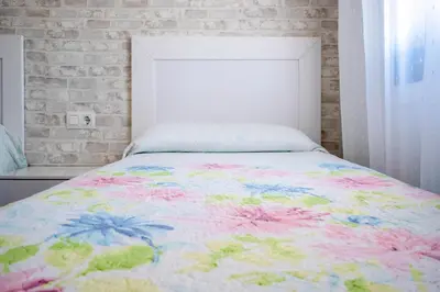 a bedroom with a bed with a colorful comforter at Casas Rurales Pericón in Conil de la Frontera