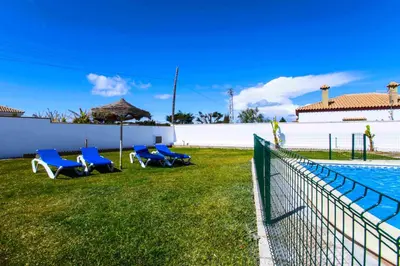a group of blue chairs next to a swimming pool at Casas Rurales Pericón in Conil de la Frontera