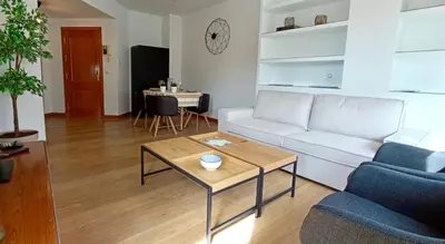 a living room with a white couch and a table at El Ático de la Angelita by RentCadiz in El Puerto de Santa María